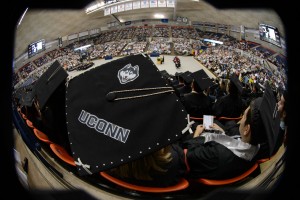 A fisheye lens view of Kelsey Claspell of New London wearing a cap decorated with Jonathan the husky during the School of Business Commencement ceremony at Gampel Pavilion on May 10, 2015. (Peter Morenus/UConn Photo)