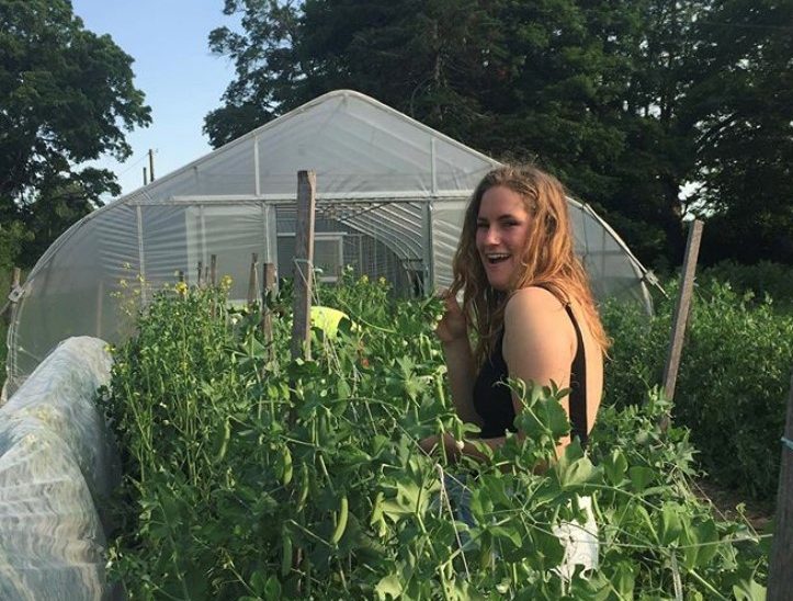 Noelle at the farm with veggie plants